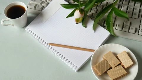 Computer keyboard, notepad, pen, cup of coffee, waffles and peony bunch Stock Footage 123994891