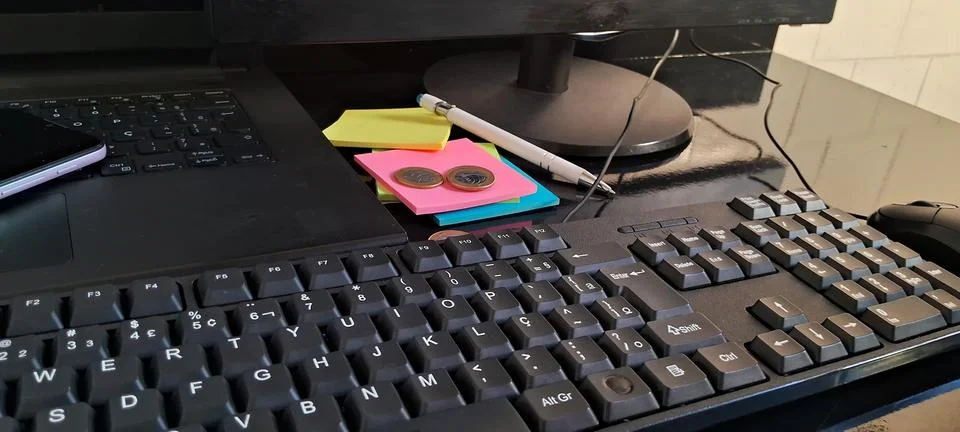 Computer keyboard on office desk. Workspace with sticky notes and digital Stockfoto's