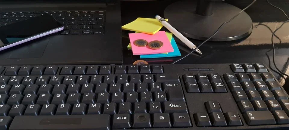 Computer keyboard on office desk. Workspace with laptop and colorful sticky Foto stock