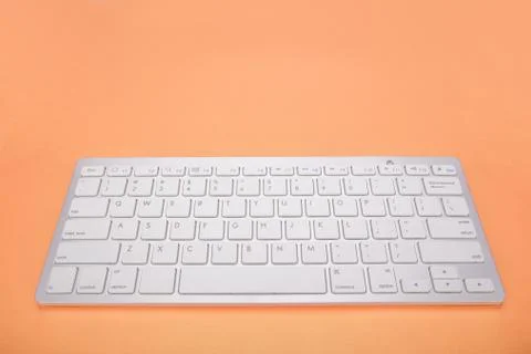 Computer keyboard on orange background Stock Photos