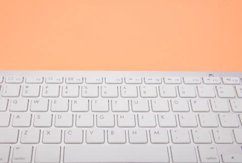 Computer keyboard on orange background Stock Photos