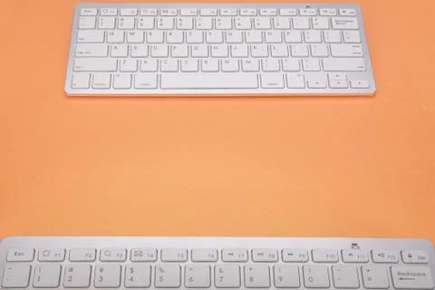 Computer keyboard on orange background Stock Photos
