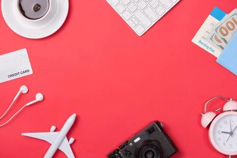 Computer keyboard, passport, plane model and credit card on red background. Stock Photos