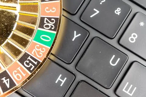 A computer keyboard with a roulette wheel overlay, representing chance, ris.. Fotos Stock
