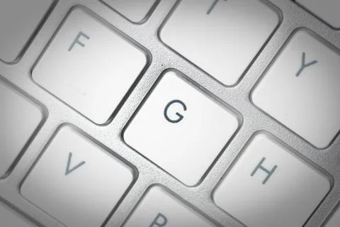 Computer keyboard - silver keyboard of a laptop with button G isolated. Home  Stock Photos