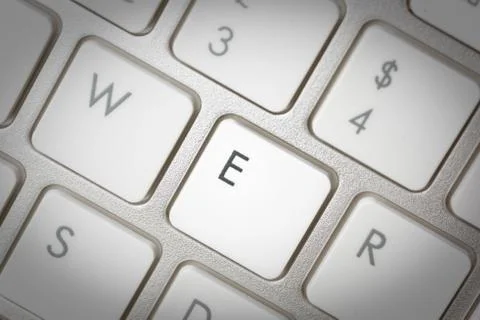 Computer keyboard - silver keyboard of a laptop with button E isolated. Home  Stock Photos