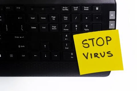 A computer keyboard with a sticky note warning about a computer Stock Photos