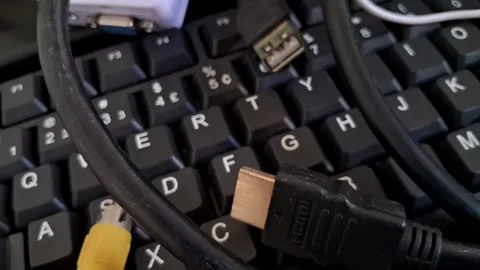 Computer keyboard with various cables. Tech hardware accessories for digital Stock Footage 340241514