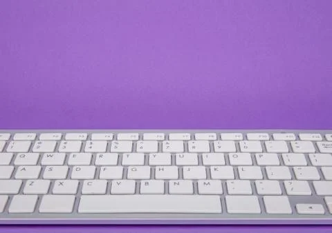 Computer keyboard on violet background Stock Photos