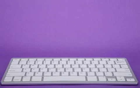 Computer keyboard on violet background Stock Photos
