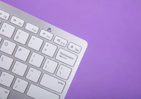 Computer keyboard on violet background Stock Photos