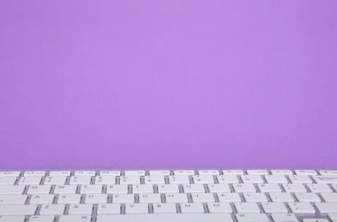 Computer keyboard on violet background Stock Photos