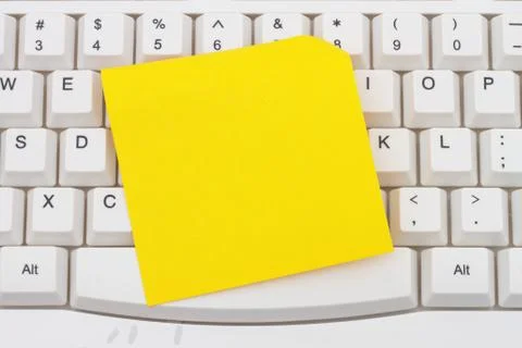 Computer Keyboard with a yellow blank sticky note Stock Photos