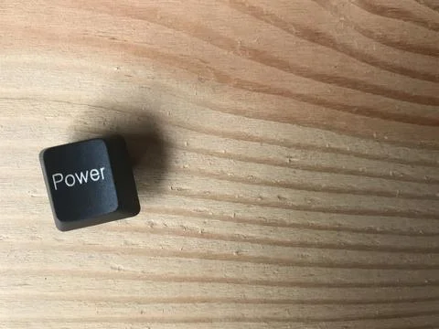 Computer keyboard's Power button on brown rubber wood table Stock Photos
