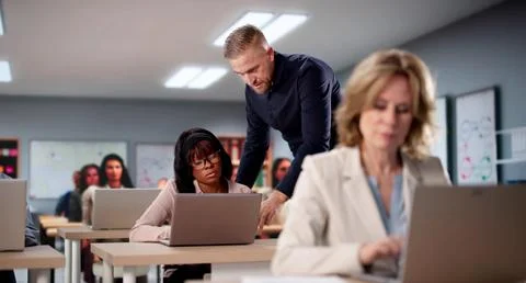 Computer Lab Professor Teaches Diverse Group Of Students Various Languages. Stock Photos