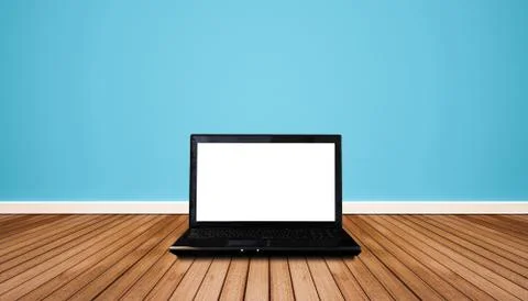 Computer laptop with blank empty white screen, on wooden floor with blue wall Stock Photos
