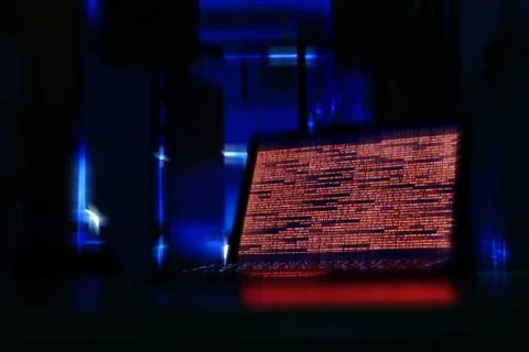 Computer laptop in a dark room. computer displaying red code meaning problem, 스톡 사진