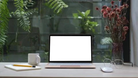 Computer laptop with empty display, coffee cup, pencil holder and houseplan.. Stock Photos