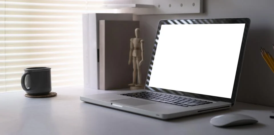 Computer laptop with empty screen, books, coffee cup and pencil holder on w.. Foto stock