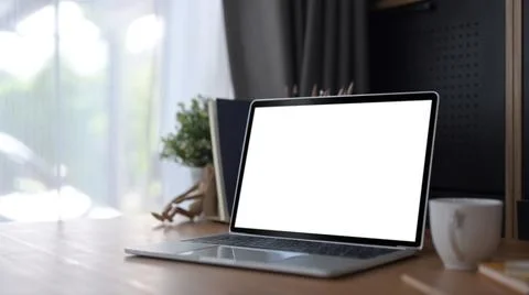 Computer laptop with empty screen, coffee cup and book on wooden table Stock Photos