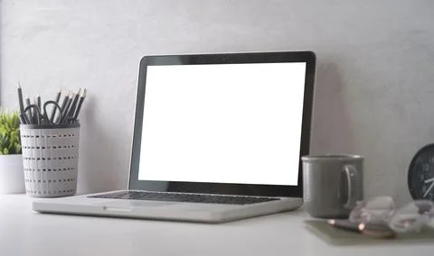 Computer laptop with empty screen, coffee cup, and potted plant on table. Hom Stock Photos