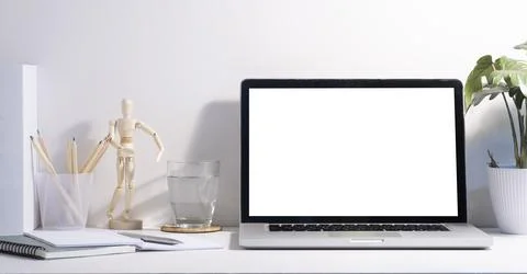 Computer laptop with empty screen, coffee cup, and potted plant on table. H.. Stock Photos