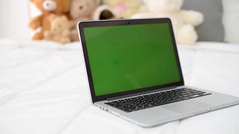 Computer laptop with green screen on bed. Vídeos de archivo 87674342