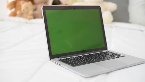 Computer laptop with green screen on bed. 库存影片 87674349