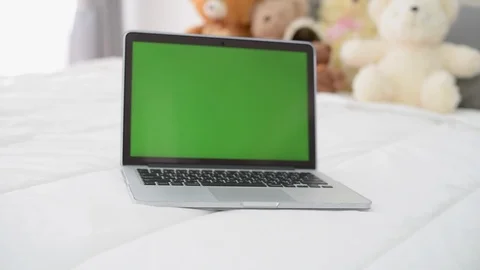 Computer laptop with green screen on bed. Vidéo 87674352
