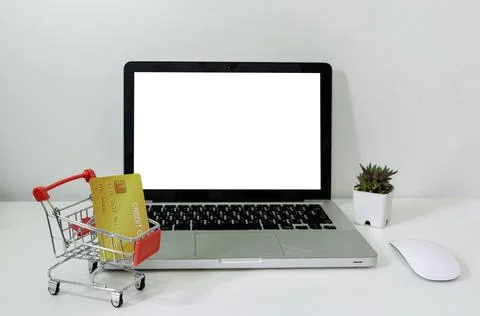Computer laptop mock up blank white and cart and credit card on desk. Used to Stock Photos