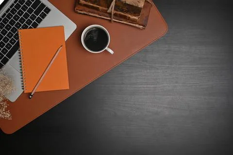 Computer laptop, notebook and coffee cup on black wooden table. Stock Photos