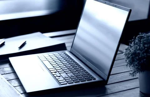 Computer laptop with paperwork on desk Stock Photos