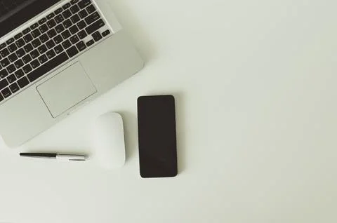 Computer laptop smart phone and mouse and pen on background top view. Stock Photos