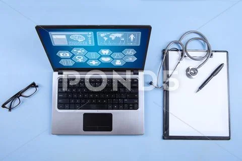 Computer laptop, stethoscope and clipboard Stock Photos