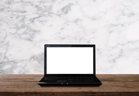 Computer laptop, white blank screen on wooden table with white marble wall Stock Photos