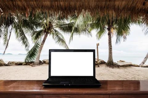 Computer laptop on wooden table, at the beach in Summer. Clipping path screen Stock Photos