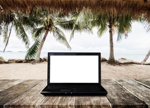 Computer laptop on wooden table, at the beach in Summer Stock Photos