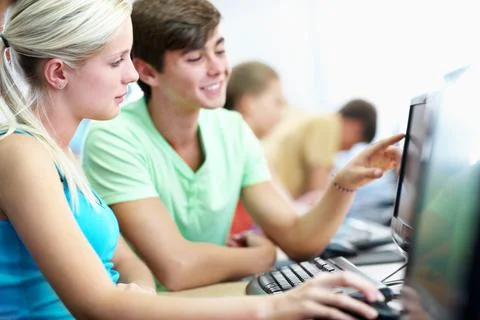 Computer, learning and conversation with students in classroom for educatio.. Stock Photos