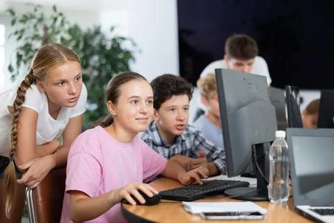 Computer lesson in classroom - classmates solve problems on computer together 스톡 사진