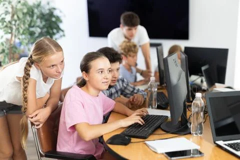 Computer lesson in classroom - classmates solve problems on computer together 스톡 사진
