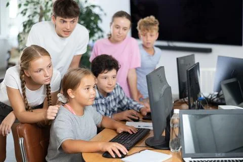 Computer lesson in classroom - classmates solve problems on computer together 스톡 사진