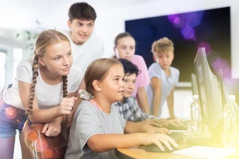 Computer lesson in classroom - classmates solve problems on computer together 스톡 사진