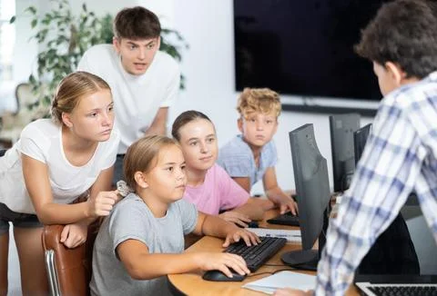 Computer lesson in classroom - classmates solve problems on computer together 스톡 사진