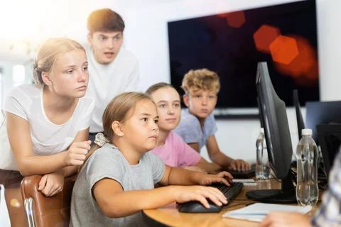 Computer lesson in classroom - classmates solve problems on computer together 스톡 사진