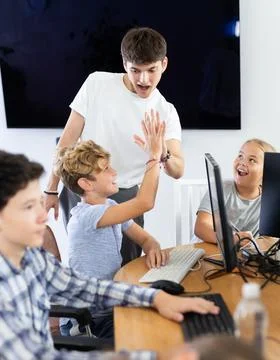 Computer lesson in classroom - successful student solved a computer problem Stock Photos