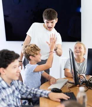Computer lesson in classroom - successful student solved a computer problem Stock Photos