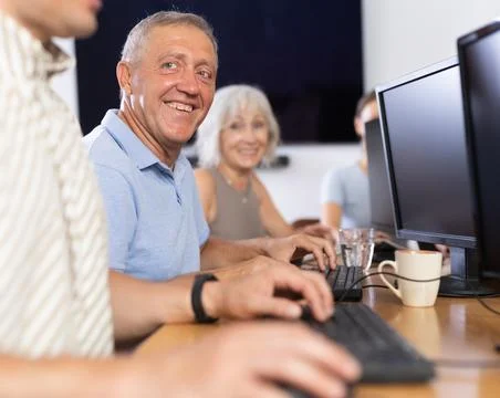 Computer lessons for elderly people in nursing home. Group of seniors learning Foto stock