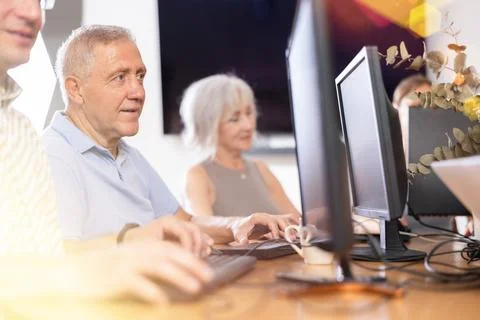 Computer lessons for elderly people in nursing home. Group of seniors learning Foto stock