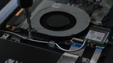 Computer maintenance. A screwdriver unscrews the screw on the fan inside the Stock Footage 297071034