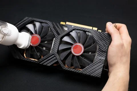 Computer master cleans the video card from dust with a vacuum cleaner Stock Photos